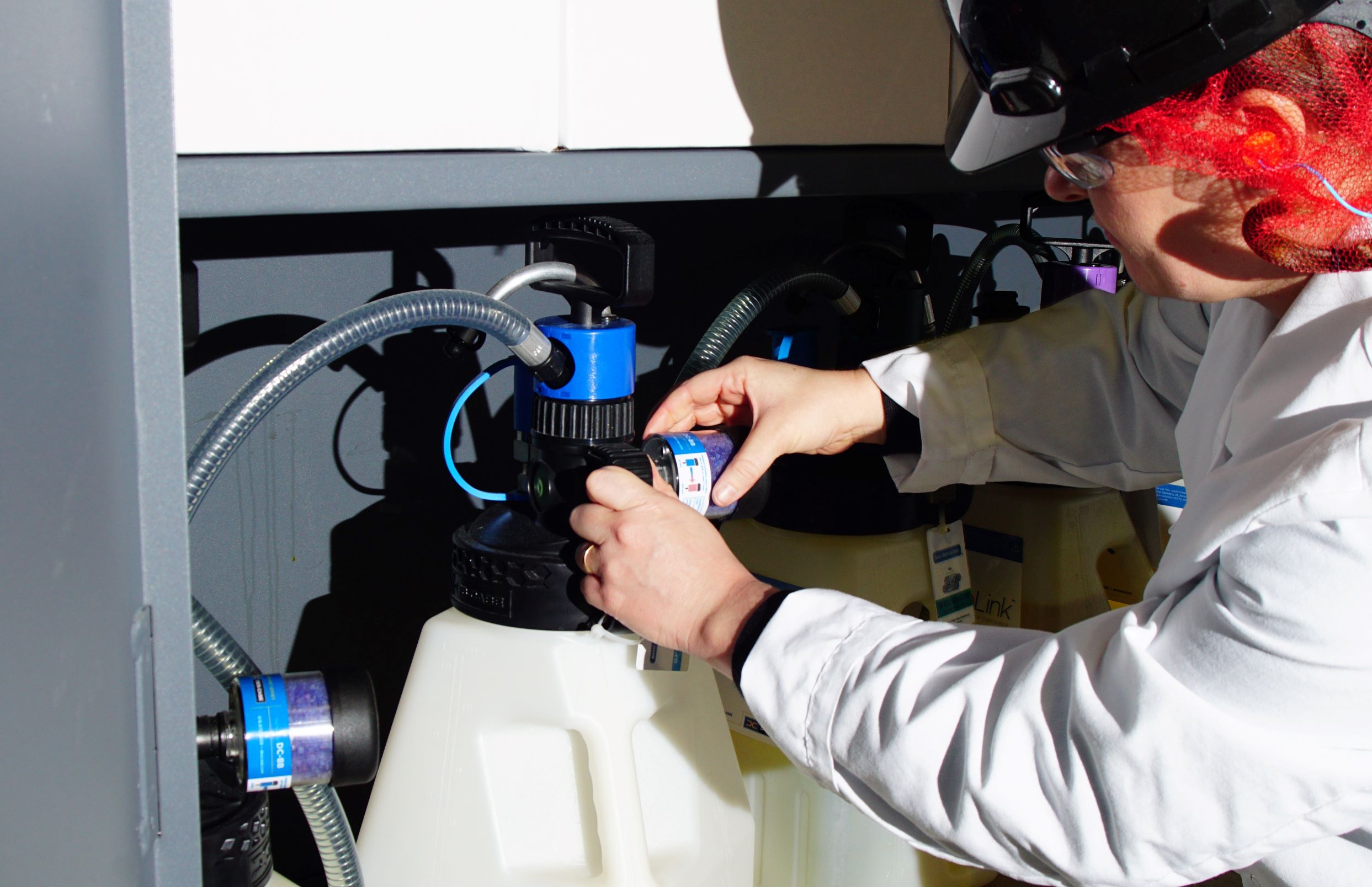 Especialista técnico utilizando estación de almacenamiento y trasvase de lubricante en sala de lubricación